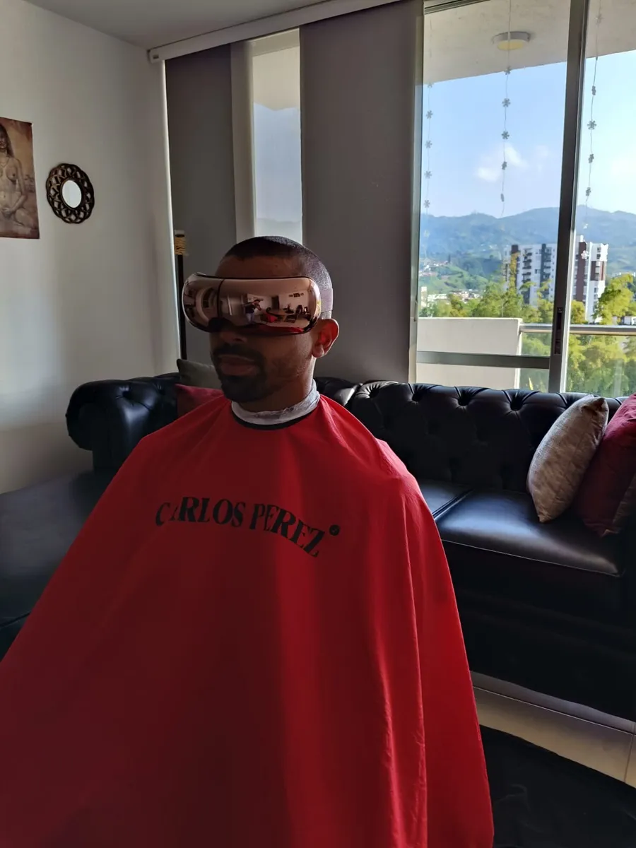 Cliente con capa de corte durante sesión a domicilio